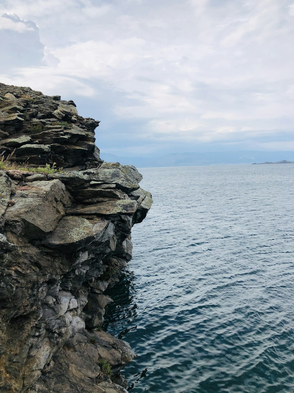 gray rocky shore under white cloudy sky during daytime