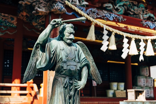man in black suit statue in Takaosan Yakuoin Temple Japan