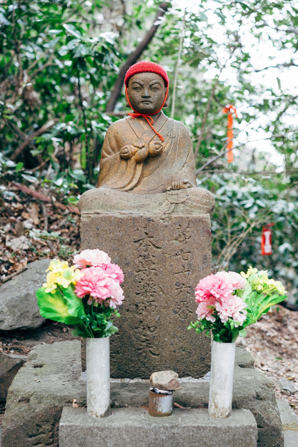 brown concrete statue with pink flowers