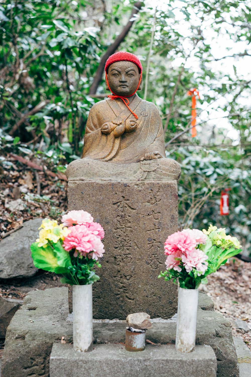 분홍색 꽃이 있는 갈색 콘크리트 동상