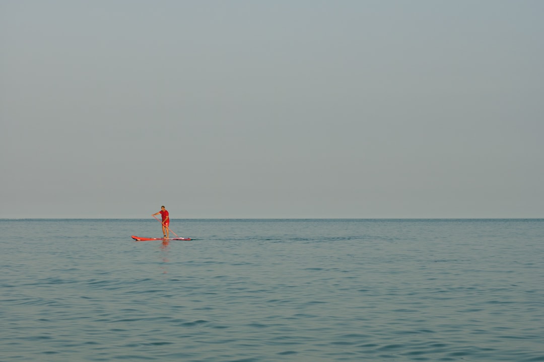 person in red shorts on body of water during daytime