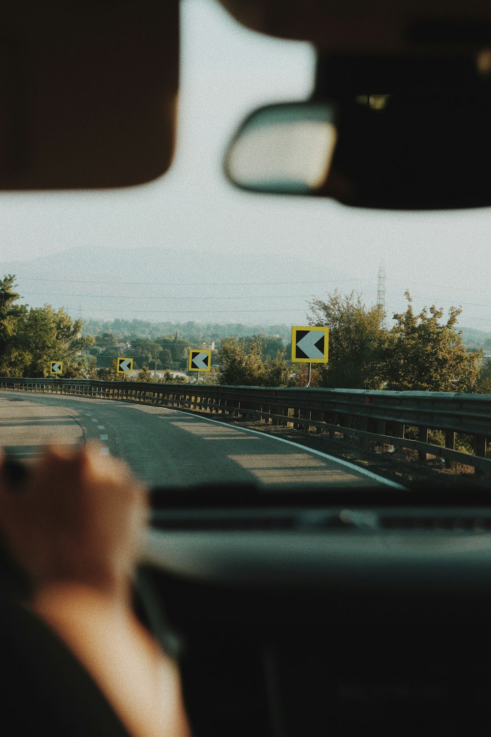 person driving car on highway during daytime