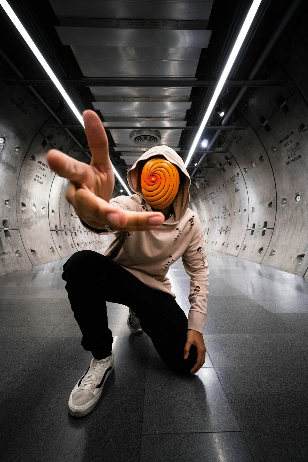 man in white t-shirt and black pants sitting on tunnel