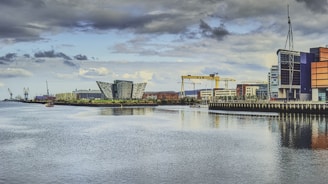 body of water near buildings under cloudy sky during daytime