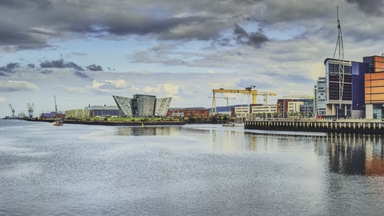 body of water near buildings under cloudy sky during daytime