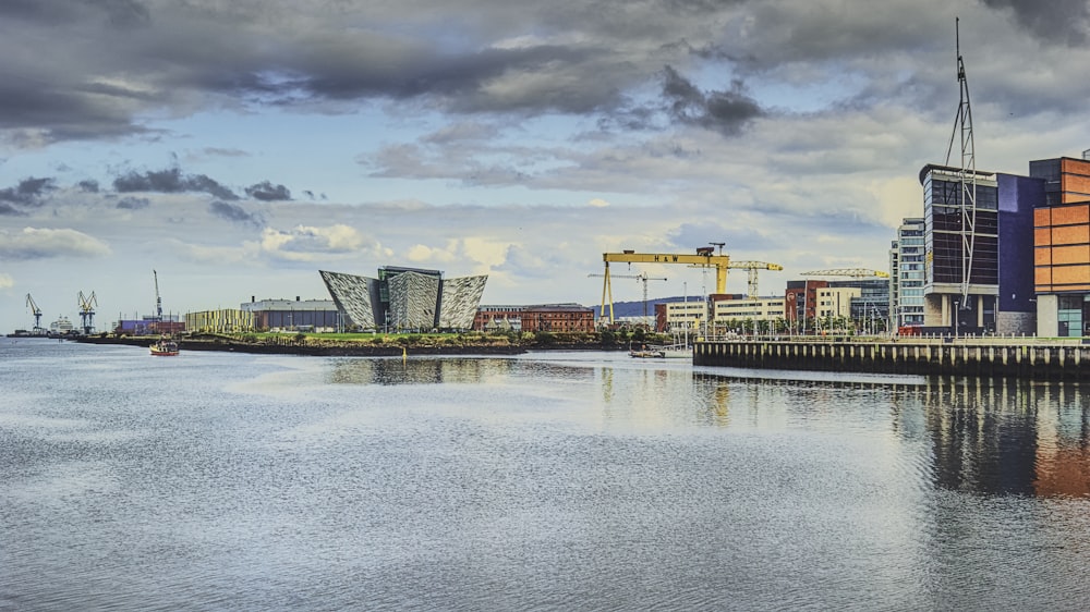 body of water near buildings under cloudy sky during daytime