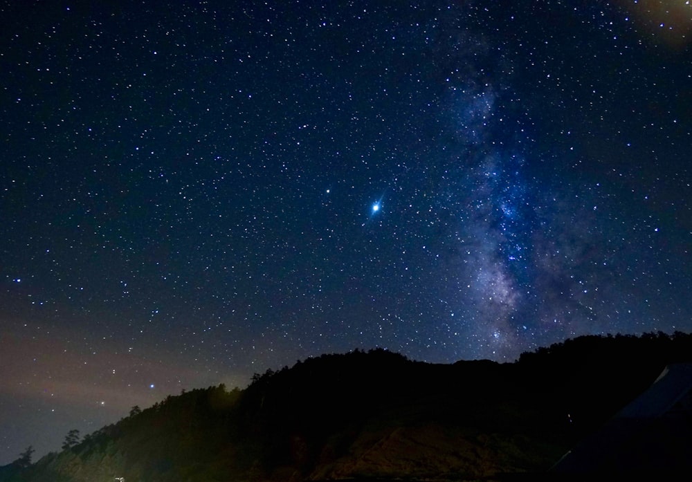 silhouette of mountain under starry night