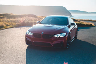 A sleek BMW M3 parked on a scenic UK countryside road under soft afternoon light.