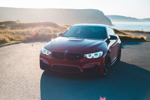 A sleek BMW M3 parked on a scenic UK countryside road under soft afternoon light.
