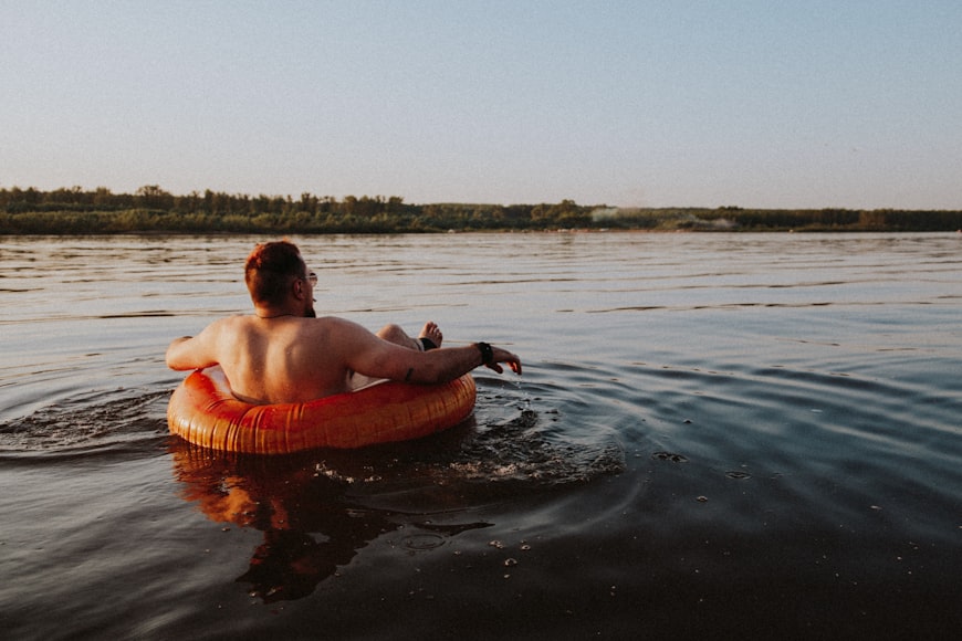 man sitting in inner tube