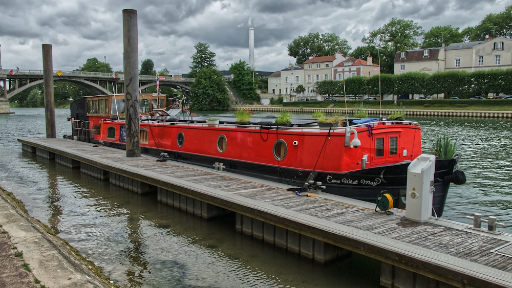 rotes und schwarzes Boot tagsüber auf dem Fluss