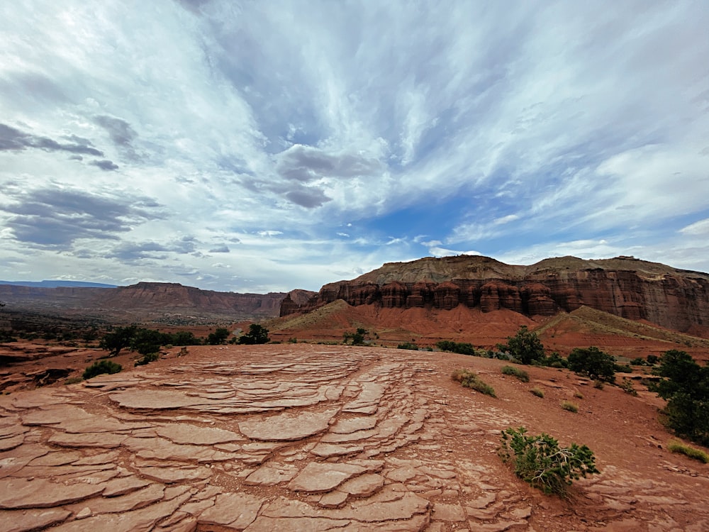 Brauner felsiger Berg unter weißen Wolken und blauem Himmel tagsüber