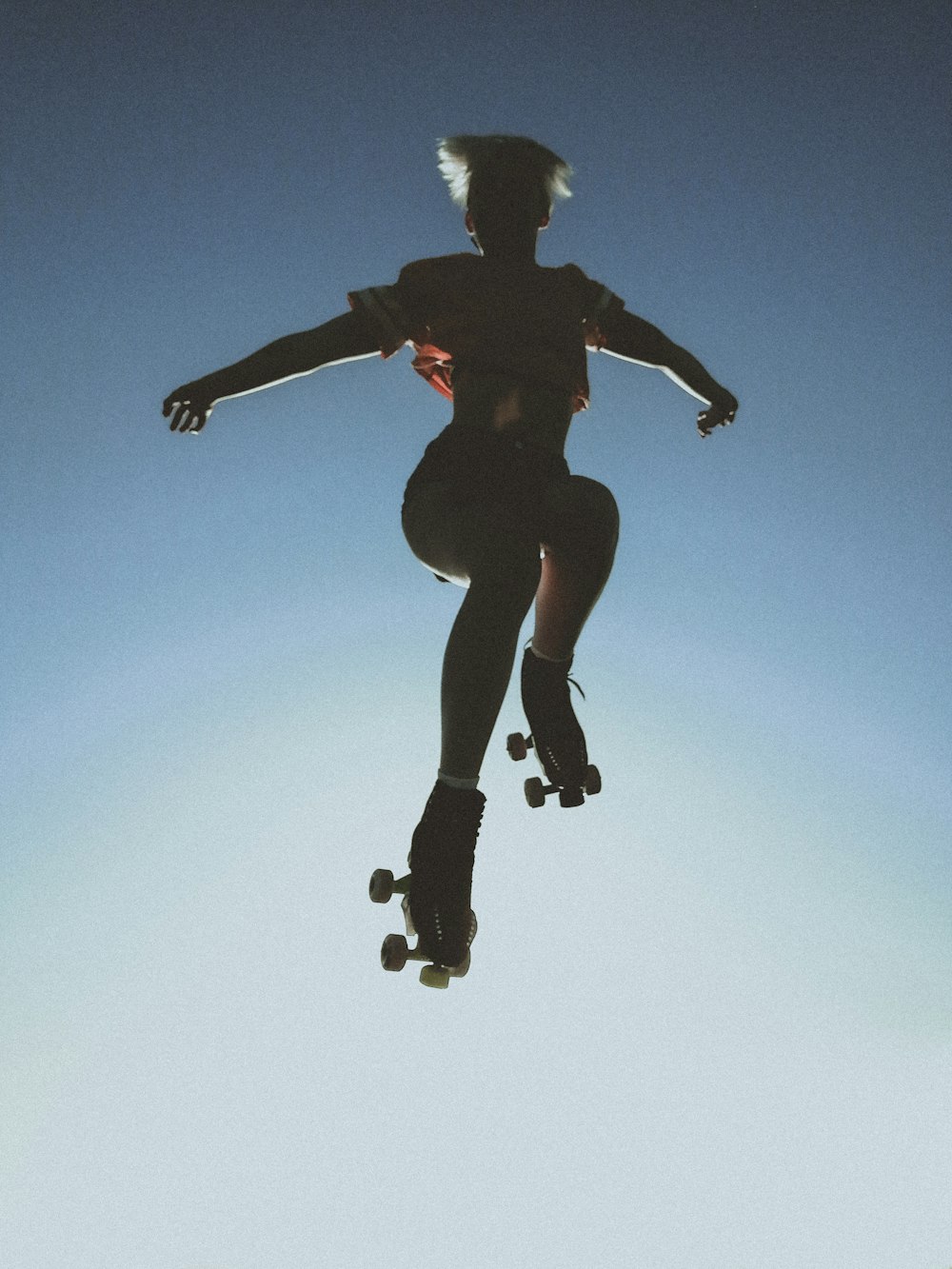 man in black jacket and black pants jumping under blue sky during daytime