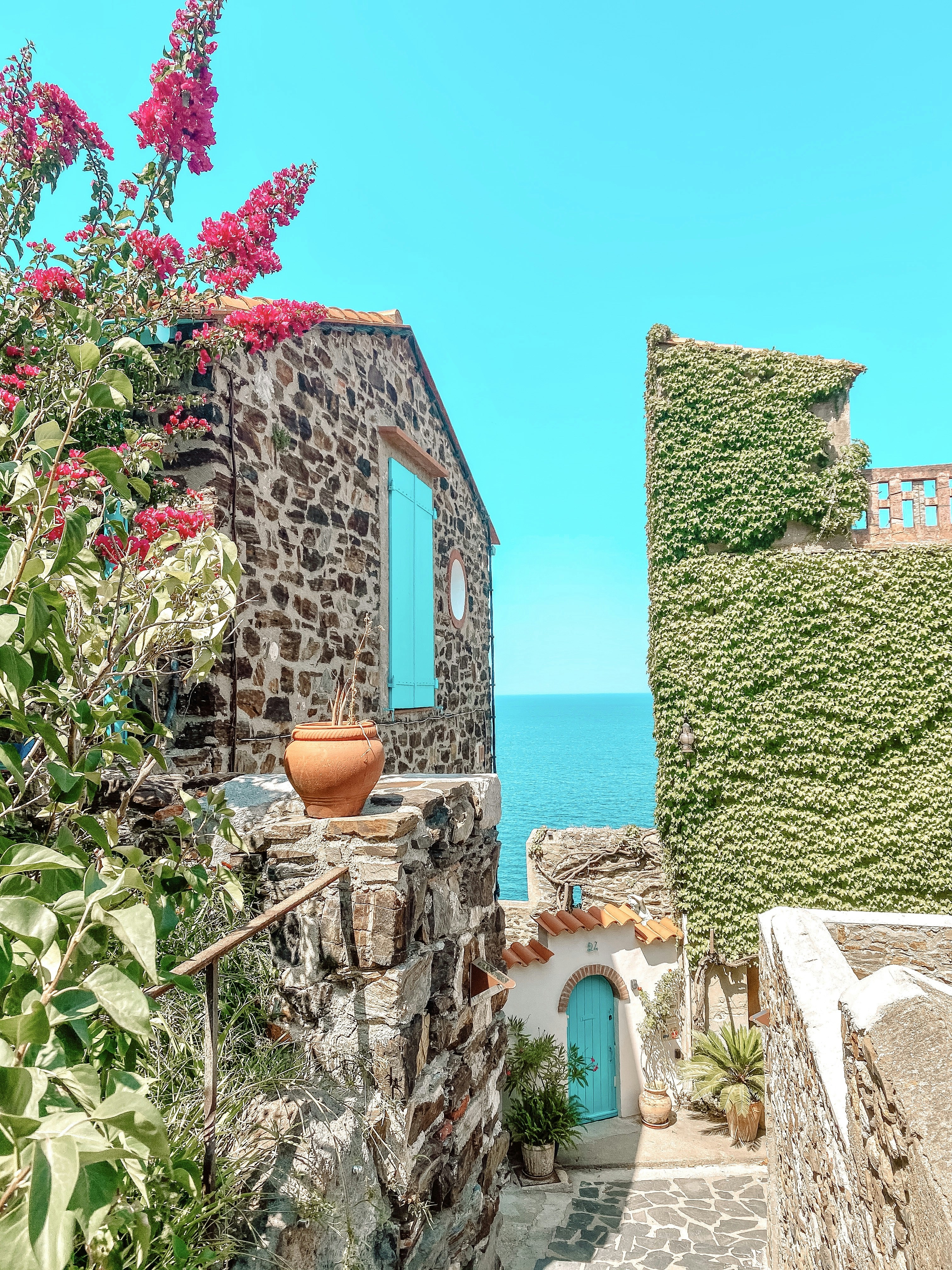 green and brown concrete house near body of water during daytime