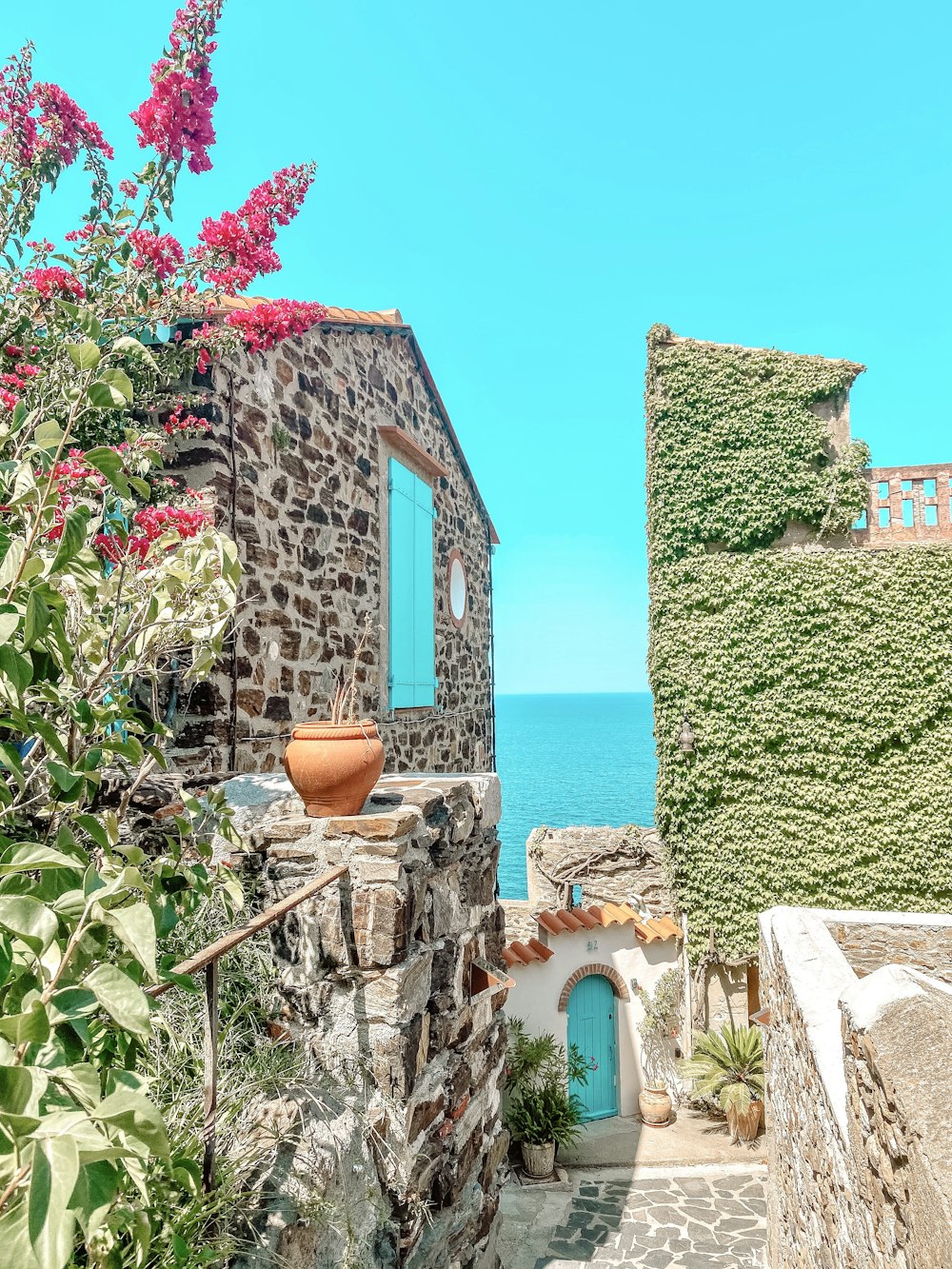 green and brown concrete house near body of water during daytime