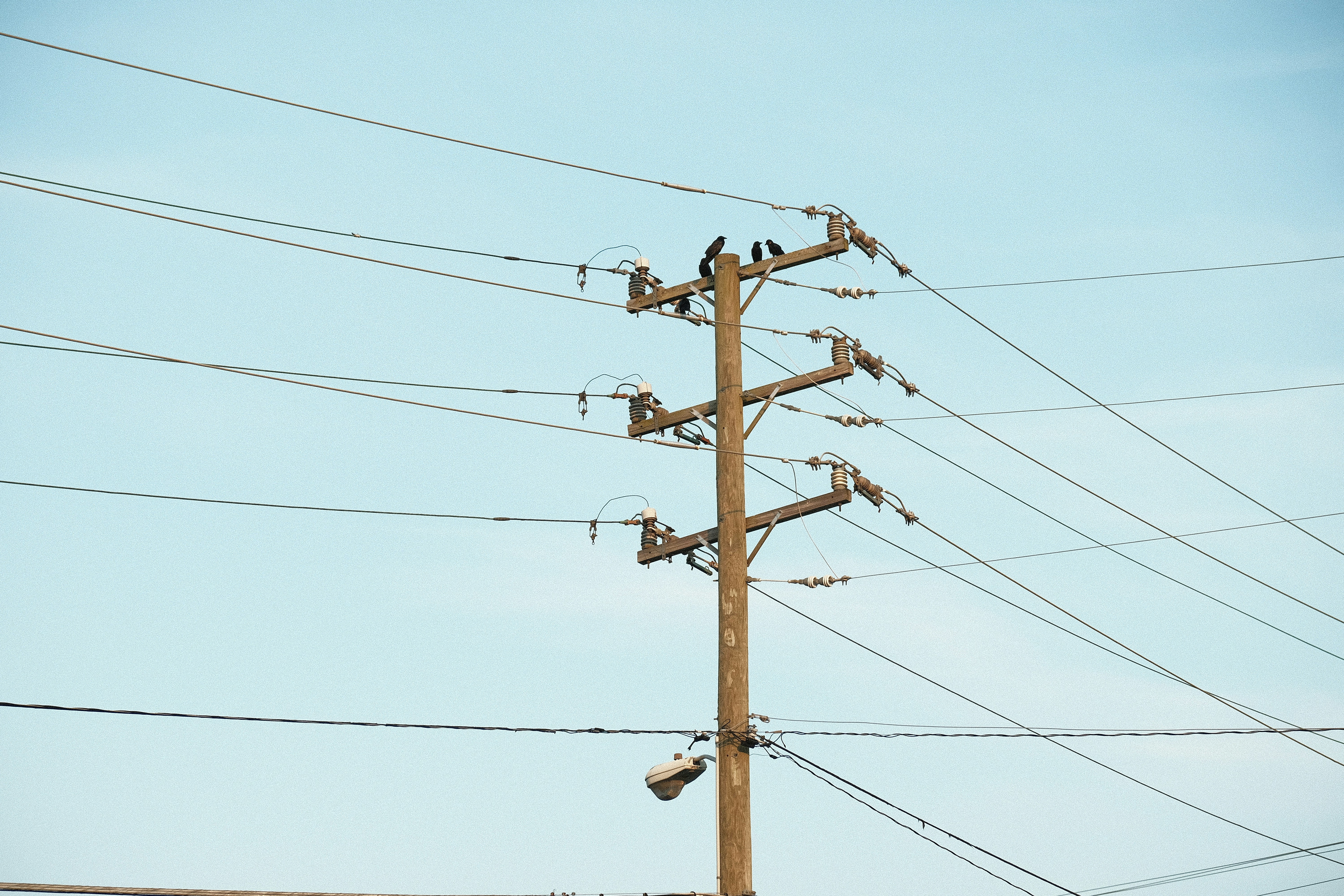 palo elettrico marrone sotto il cielo grigio durante il giorno