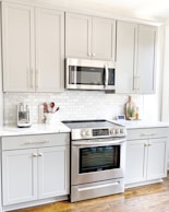 white microwave oven on white wooden cabinet