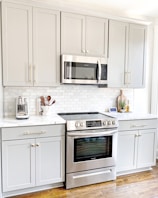 white microwave oven on white wooden cabinet