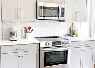 white microwave oven on white wooden cabinet