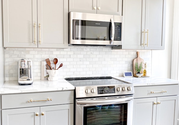 white microwave oven on white wooden cabinet