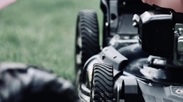 black and red ride on lawn mower on green grass field during daytime