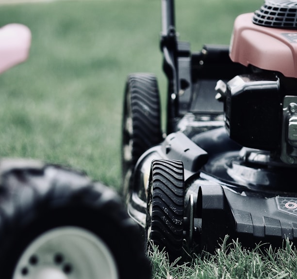 black and red ride on lawn mower on green grass field during daytime