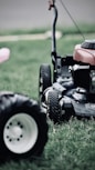 black and red ride on lawn mower on green grass field during daytime