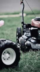 black and red ride on lawn mower on green grass field during daytime