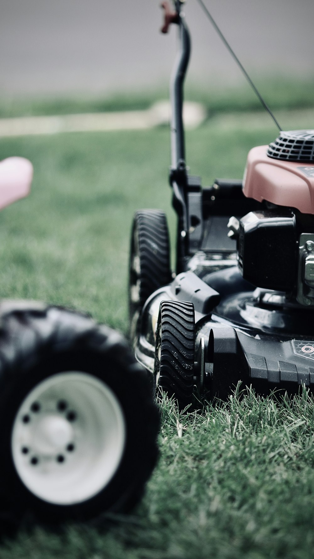 black and red ride on lawn mower on green grass field during daytime