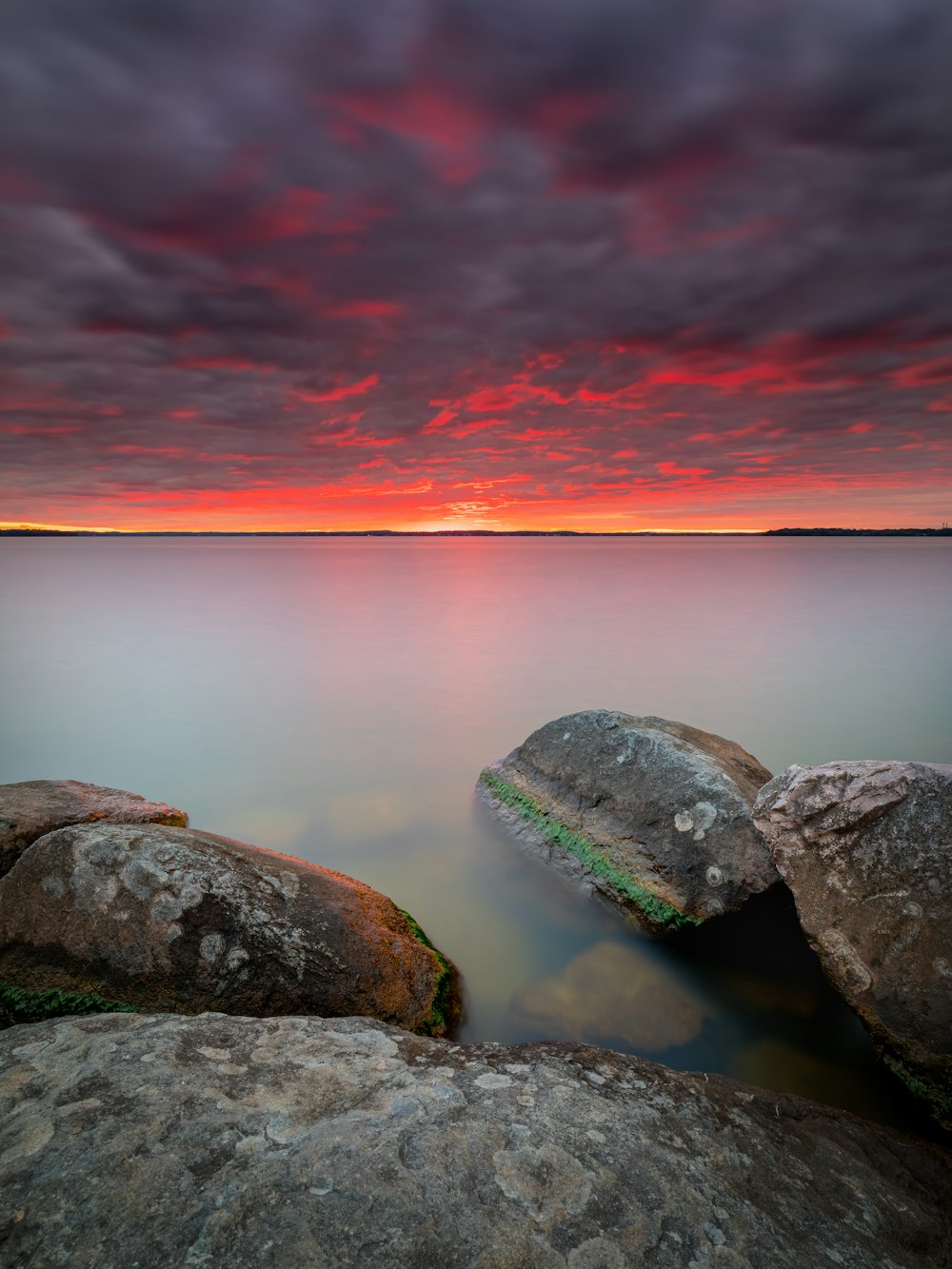 gray and black rock formation near body of water during sunset