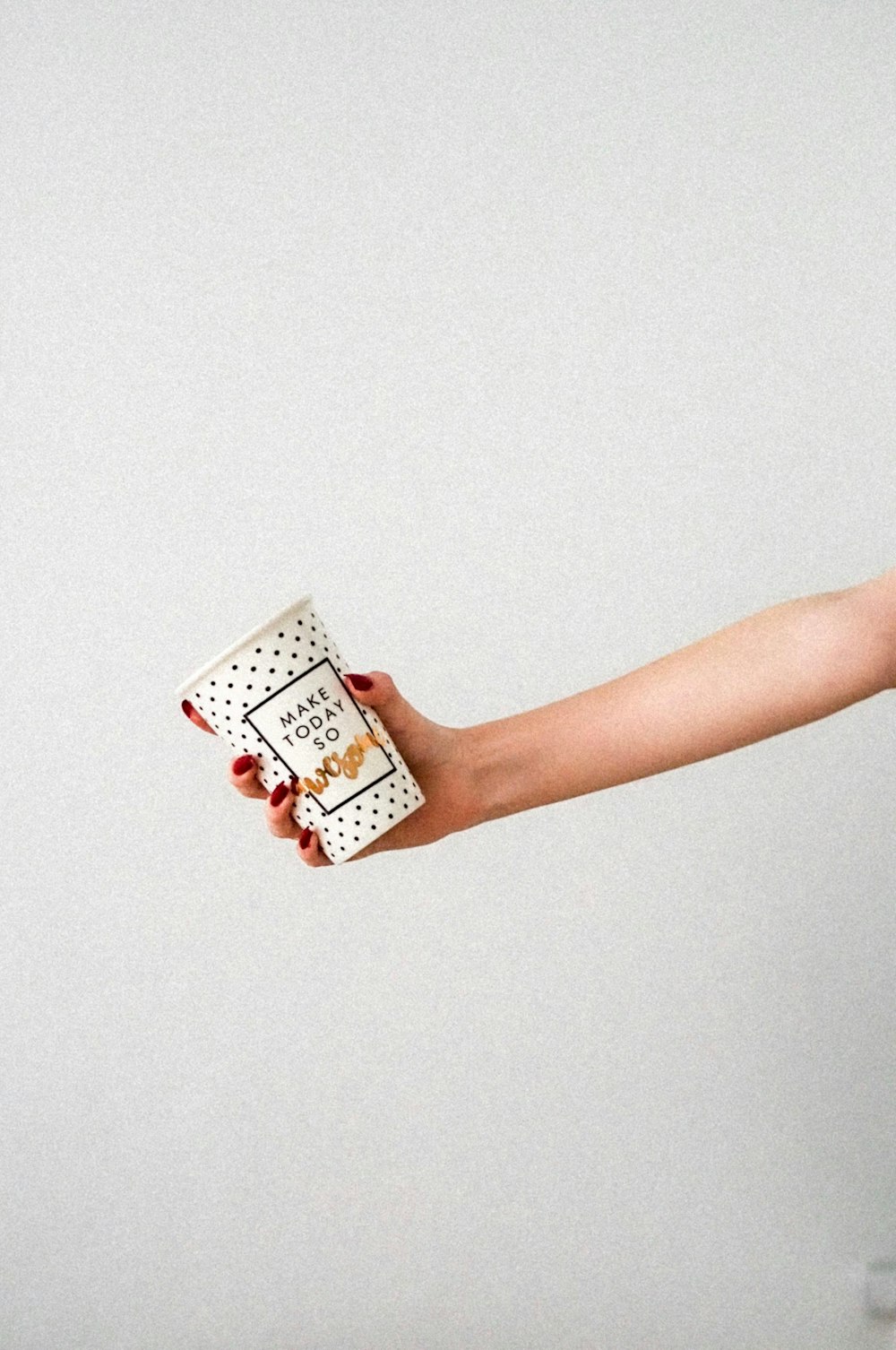 person holding white and black ceramic mug