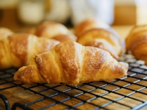 Close-up of golden croissants with a hint of steam rising, showcasing freshness.