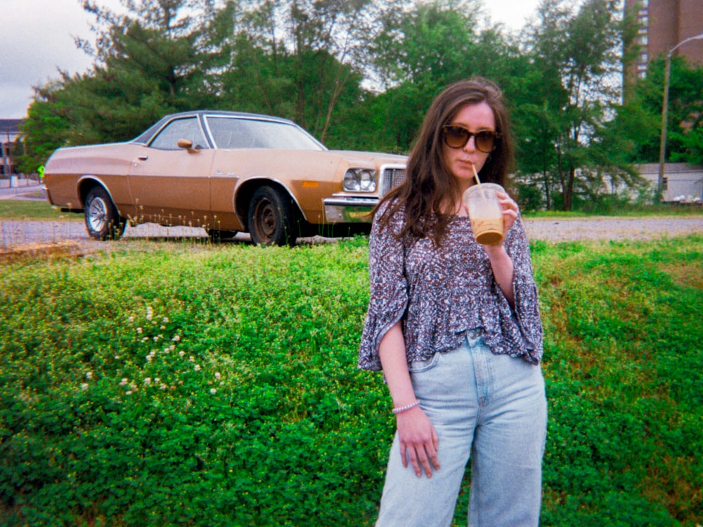 woman in blue and white floral blouse and gray pants holding white ceramic mug