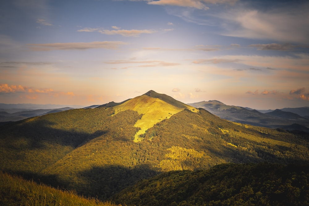 green and brown mountain under white clouds during daytime