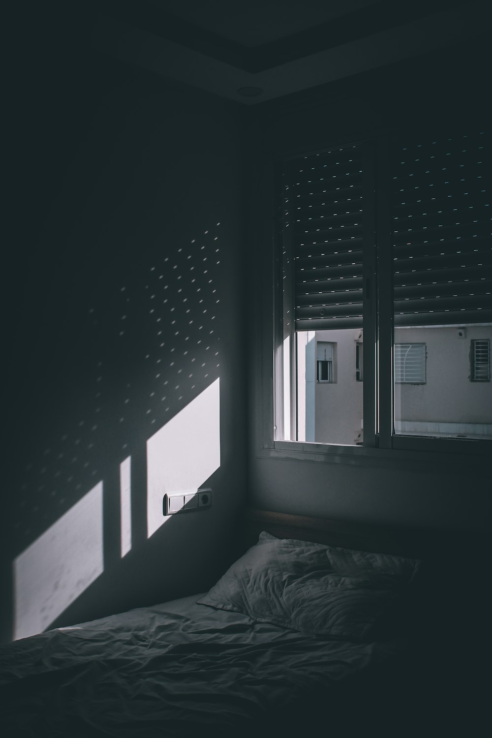 grayscale photo of bed near window