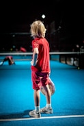 girl in red t-shirt and black pants running on blue floor