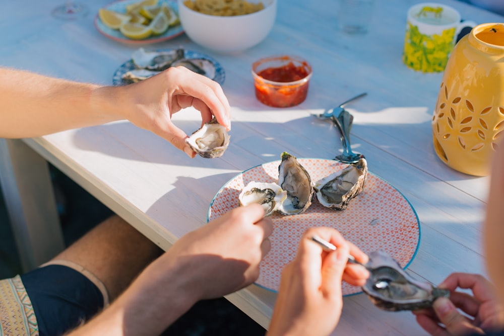 person holding a silver fish on a table
