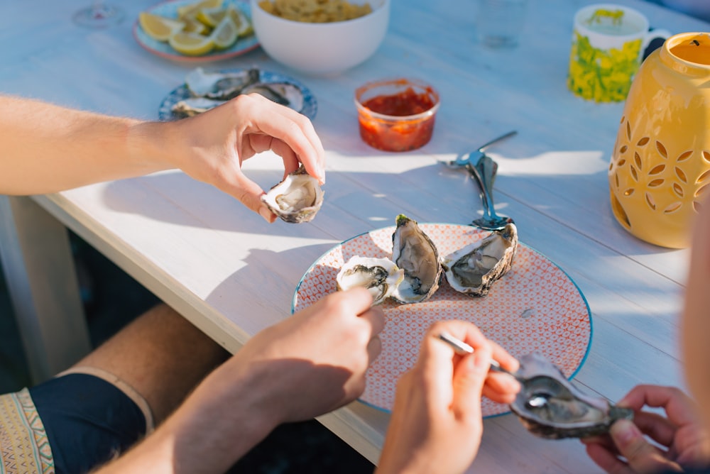 persona sosteniendo un pez plateado en una mesa