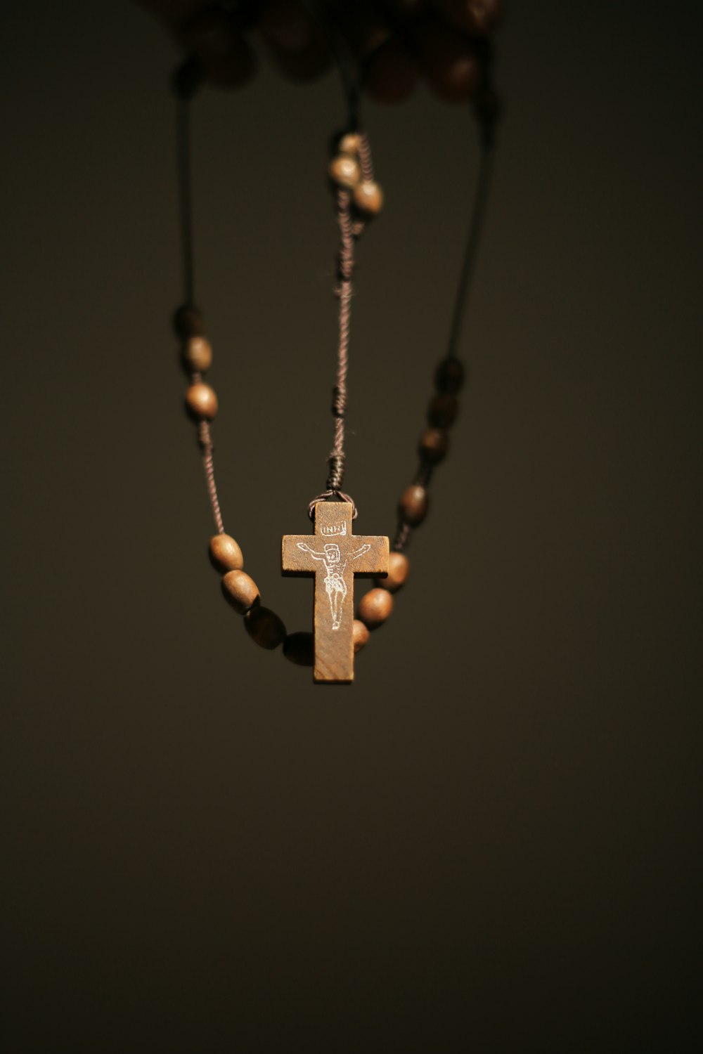 gold cross pendant necklace on black background