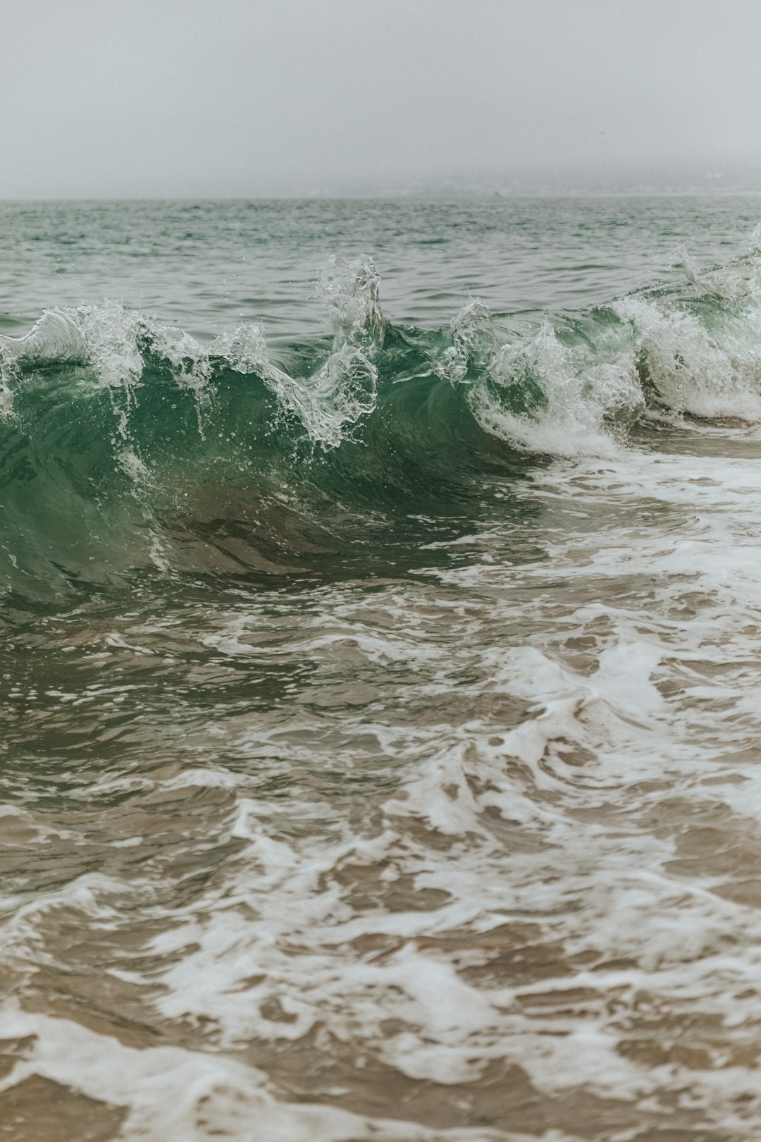 ocean waves crashing on shore during daytime