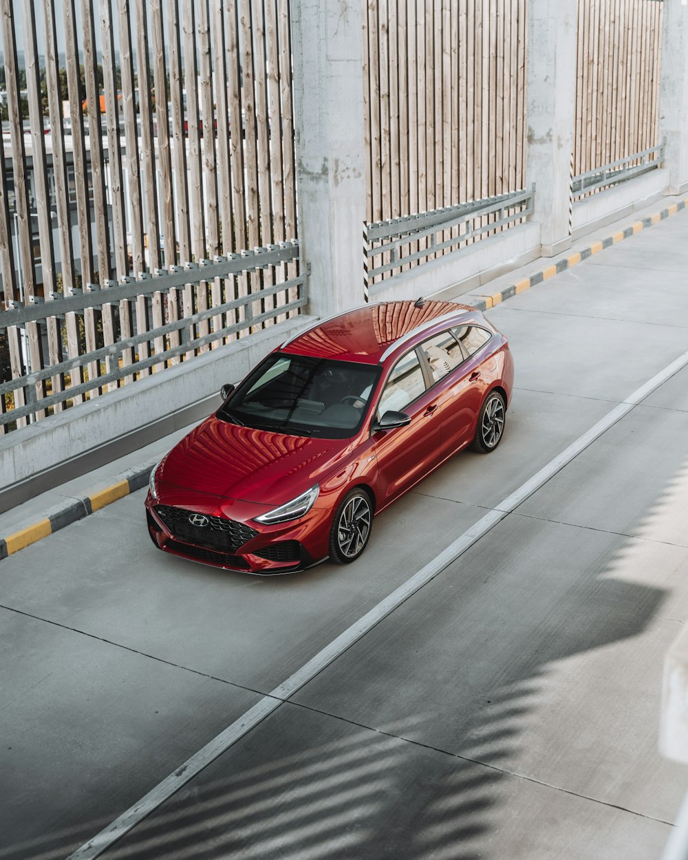 red sedan parked on sidewalk during daytime