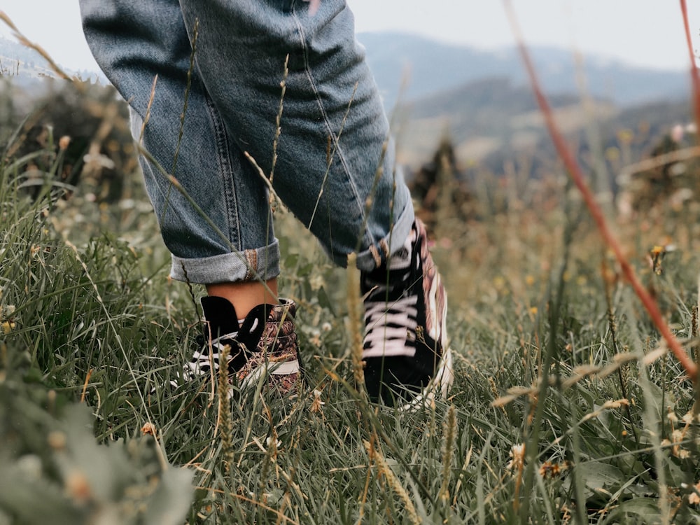 Foto de persona en jeans azules y zapatillas adidas blancas y negras de pie  en un campo de hierba verde – Imagen gratuita Furgonetas en Unsplash