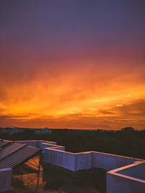 A sleek rooftop solar panel array glowing with solar orange accent lighting under a twilight sky.
