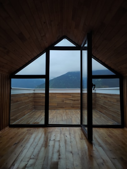 Cozy rustic suite with wooden furniture and a balcony overlooking lush Atlantic forest.