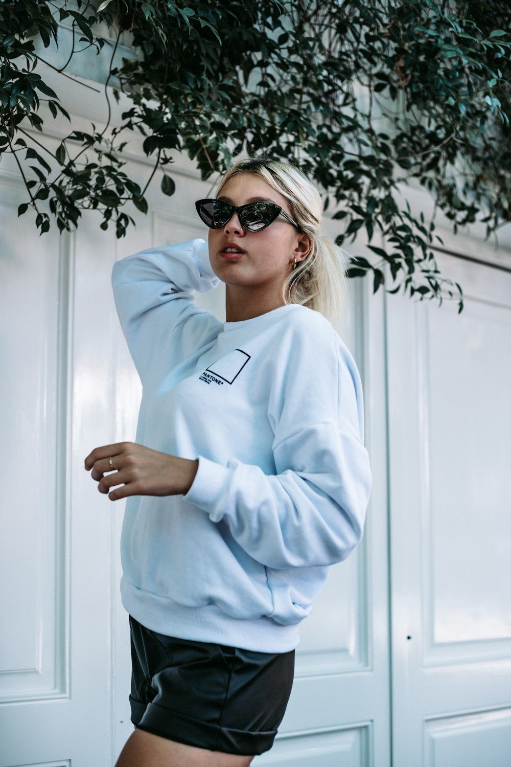 Mujer con camisa azul de manga larga con gafas de sol negras