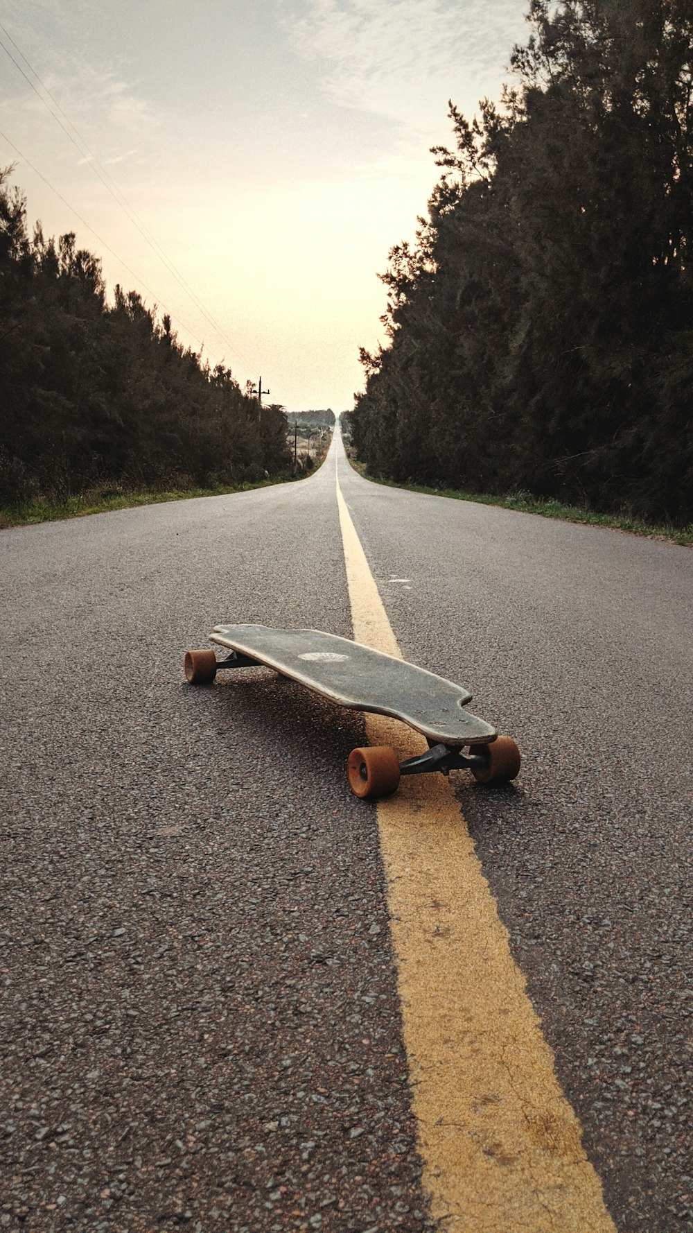 orange and black skateboard on gray asphalt road during daytime