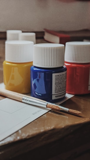 white and blue plastic bottle beside white and brown pen