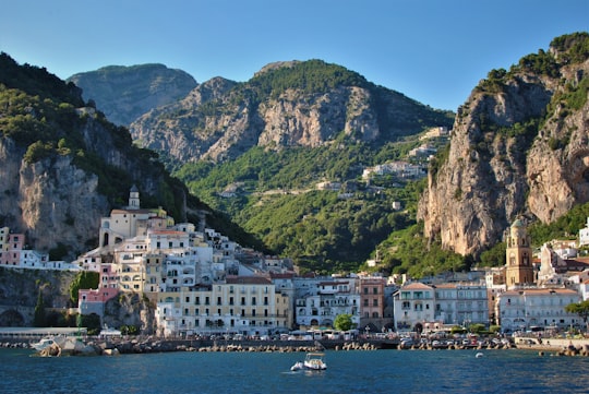 white and brown concrete buildings near body of water during daytime in Amalfi Coast Italy