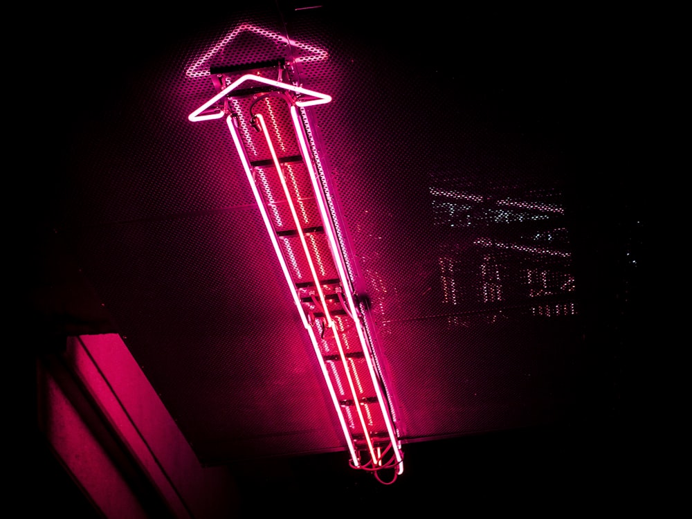 Segnaletica luminosa al neon viola accesa durante la notte