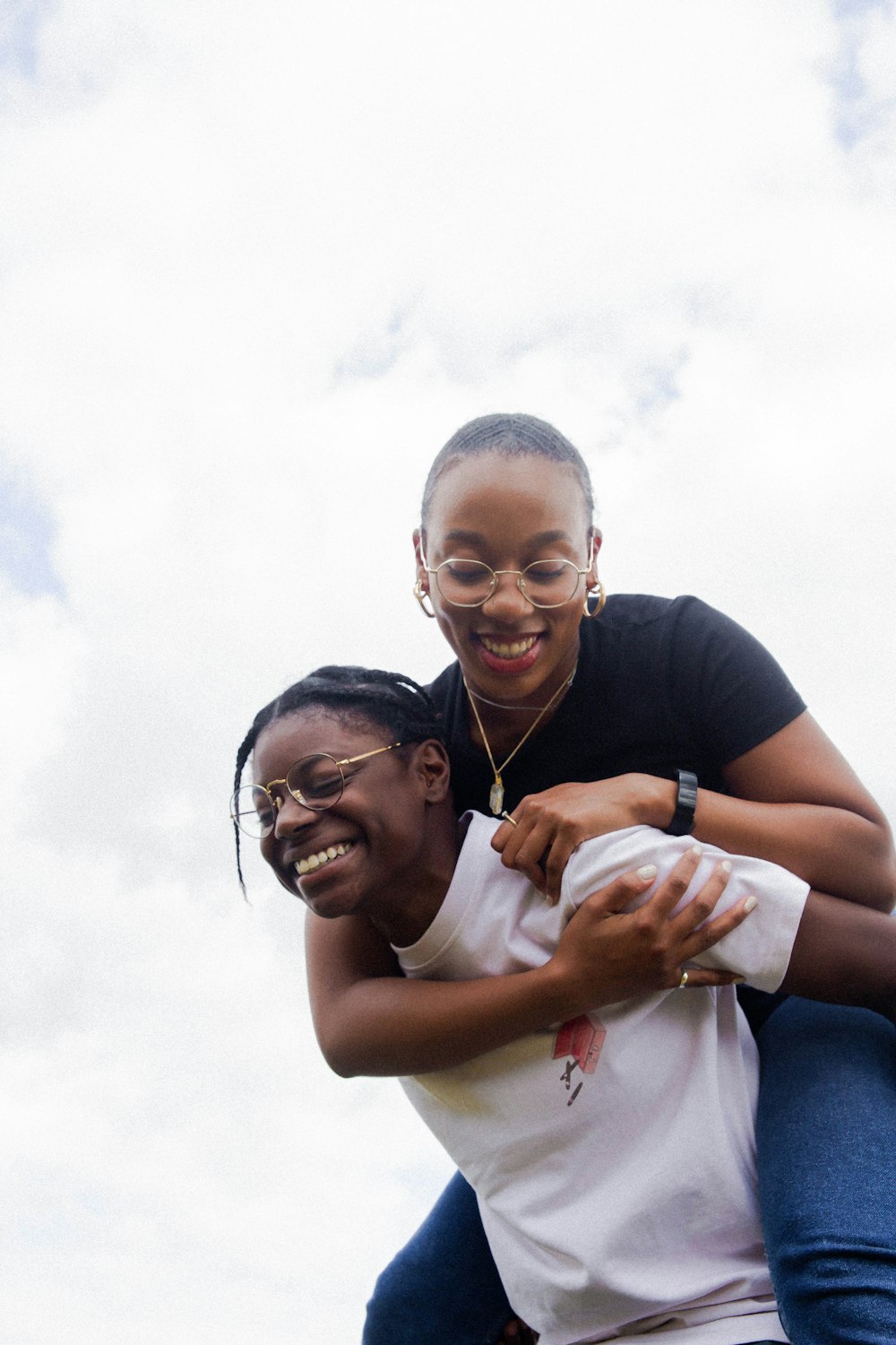 woman in white t-shirt carrying girl in black top